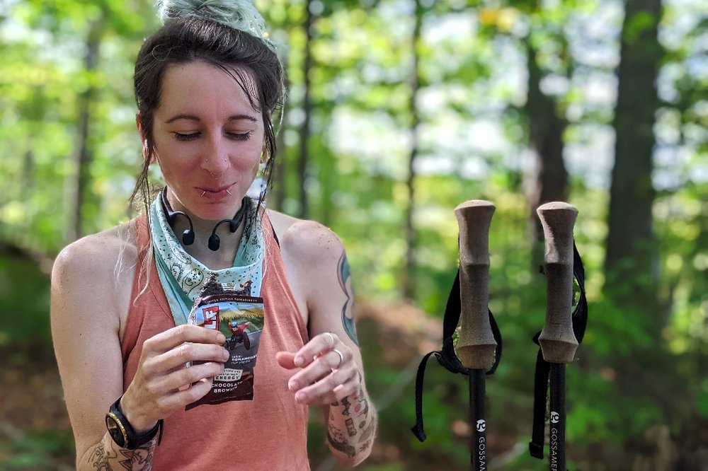 A hiker eating a Clif Bar