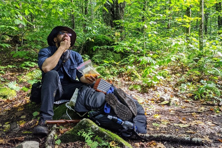 A Long Trail hiker having a snack in the forest