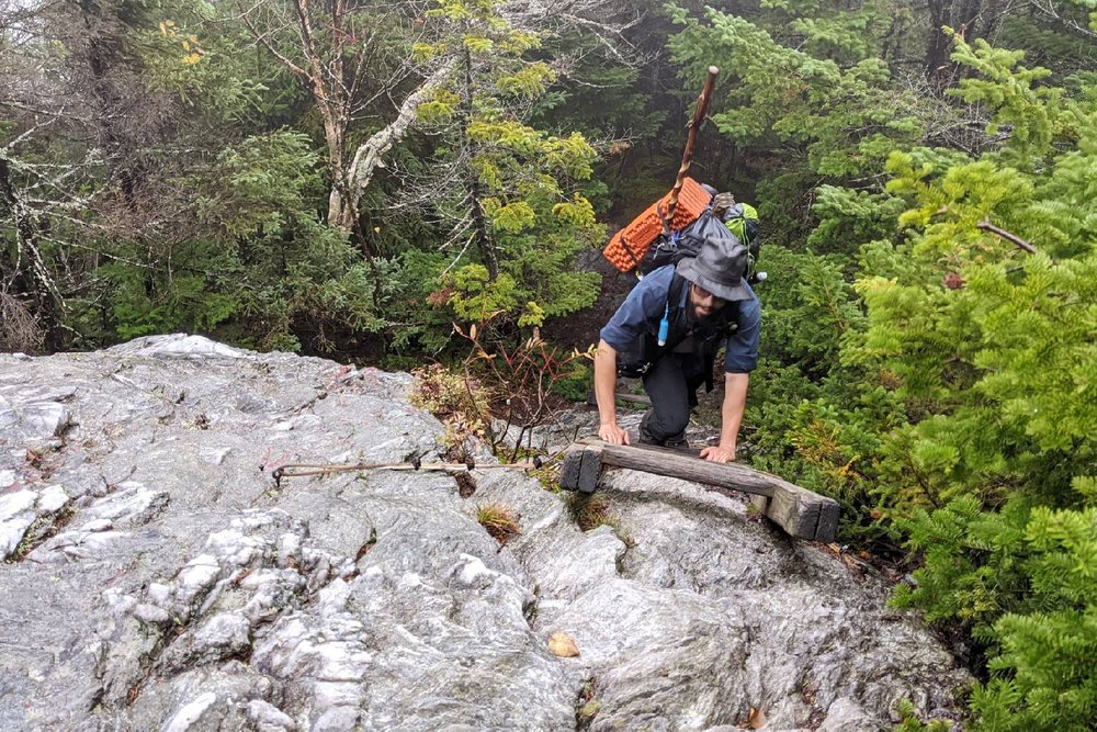 A Long Trail hiker climbing up a ladder