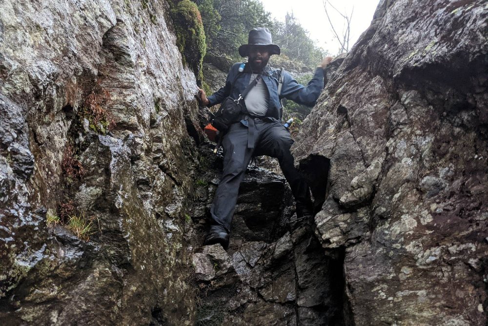 A Long Trail hiker climbing down some steep rocks