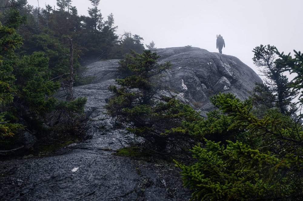 A Long Trail hiker traversing a rocky summit