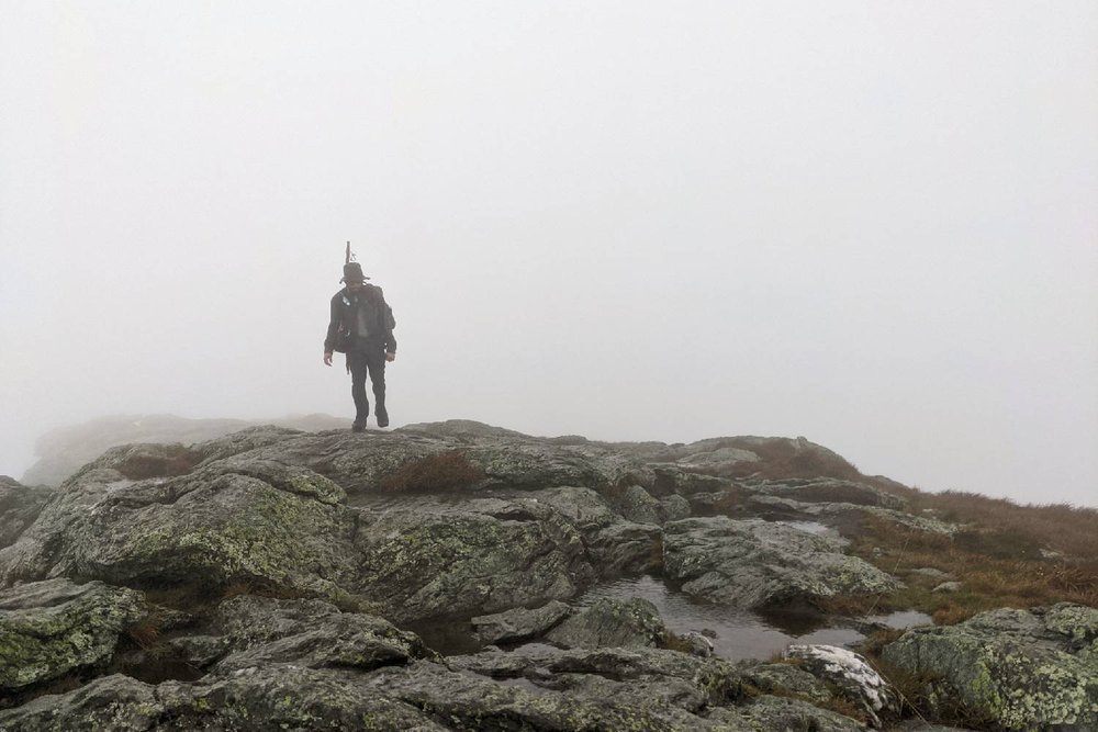 A Long Trail hiker traversing a rocky summit