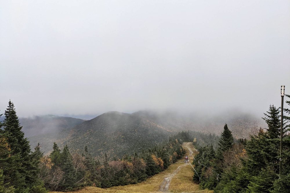 A foggy view of a ski trail and some mountains on the Long Trail
