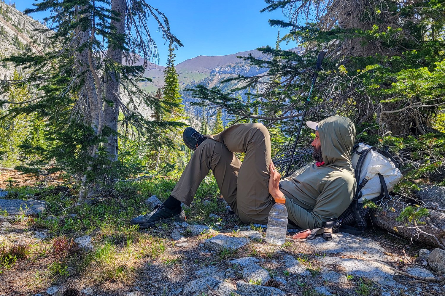 A hiker lounging against his backpack with his feet up, there