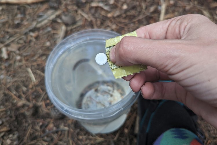 A chlorine dioxide pill being dropped into water