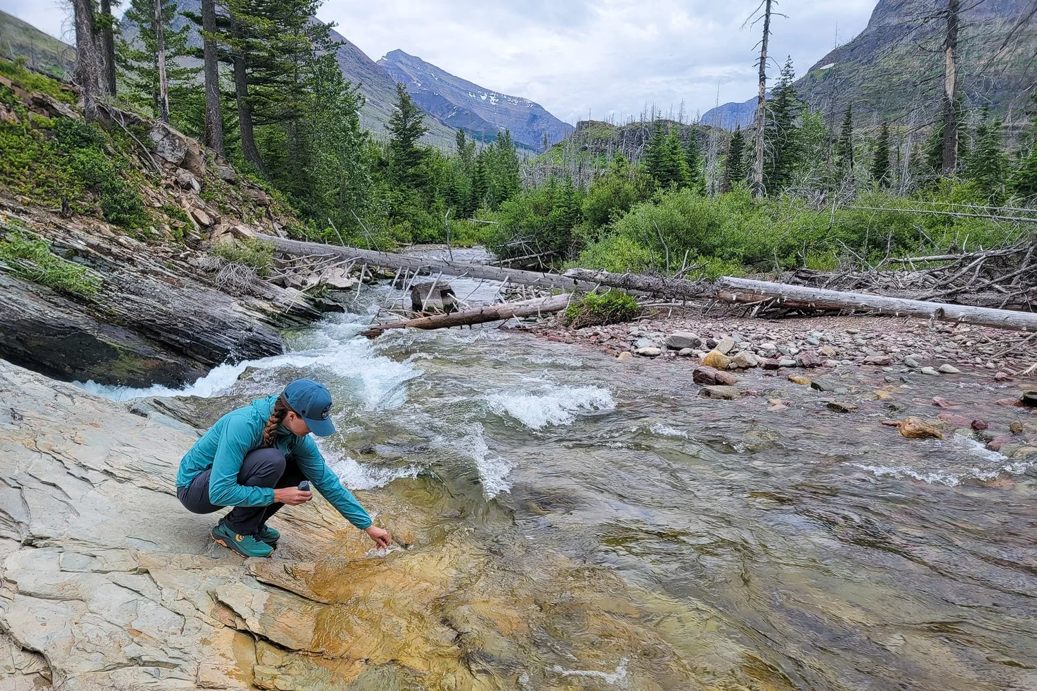 A backpacker collecting water in the Platypus QuickDraw 1 L reservoir