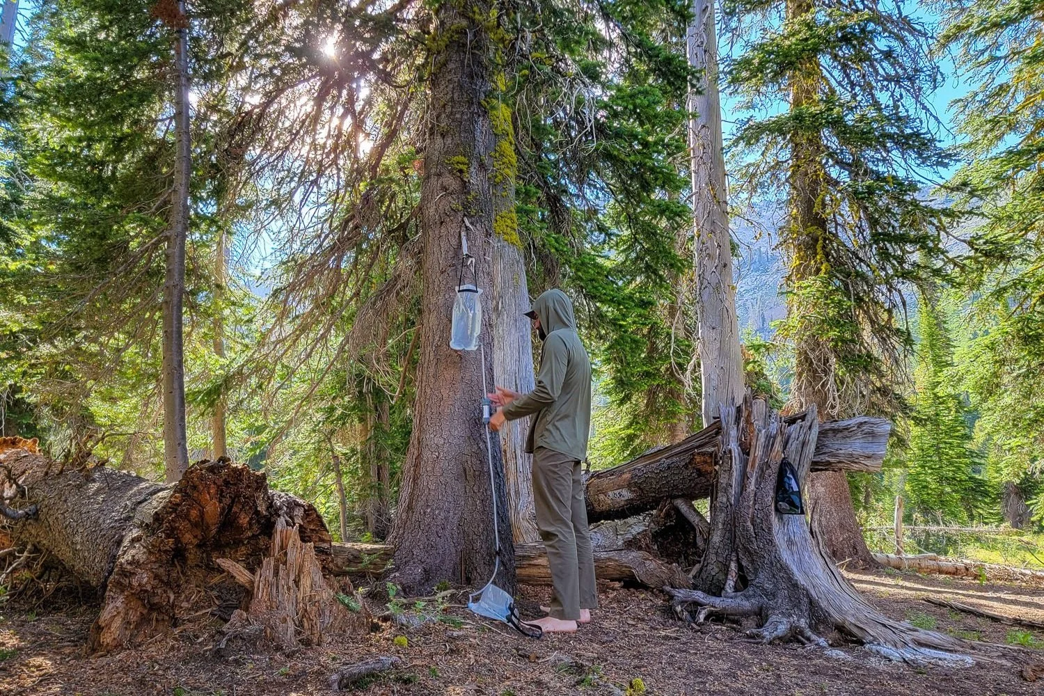 A backpacker using the Platypus GravityWorks water filter
