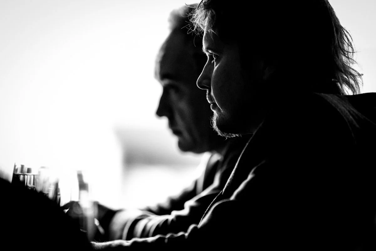 Pensive chefs Grant Achatz and Ferran Adria being interviewed by a journalist (Balena, Chicago, IL).