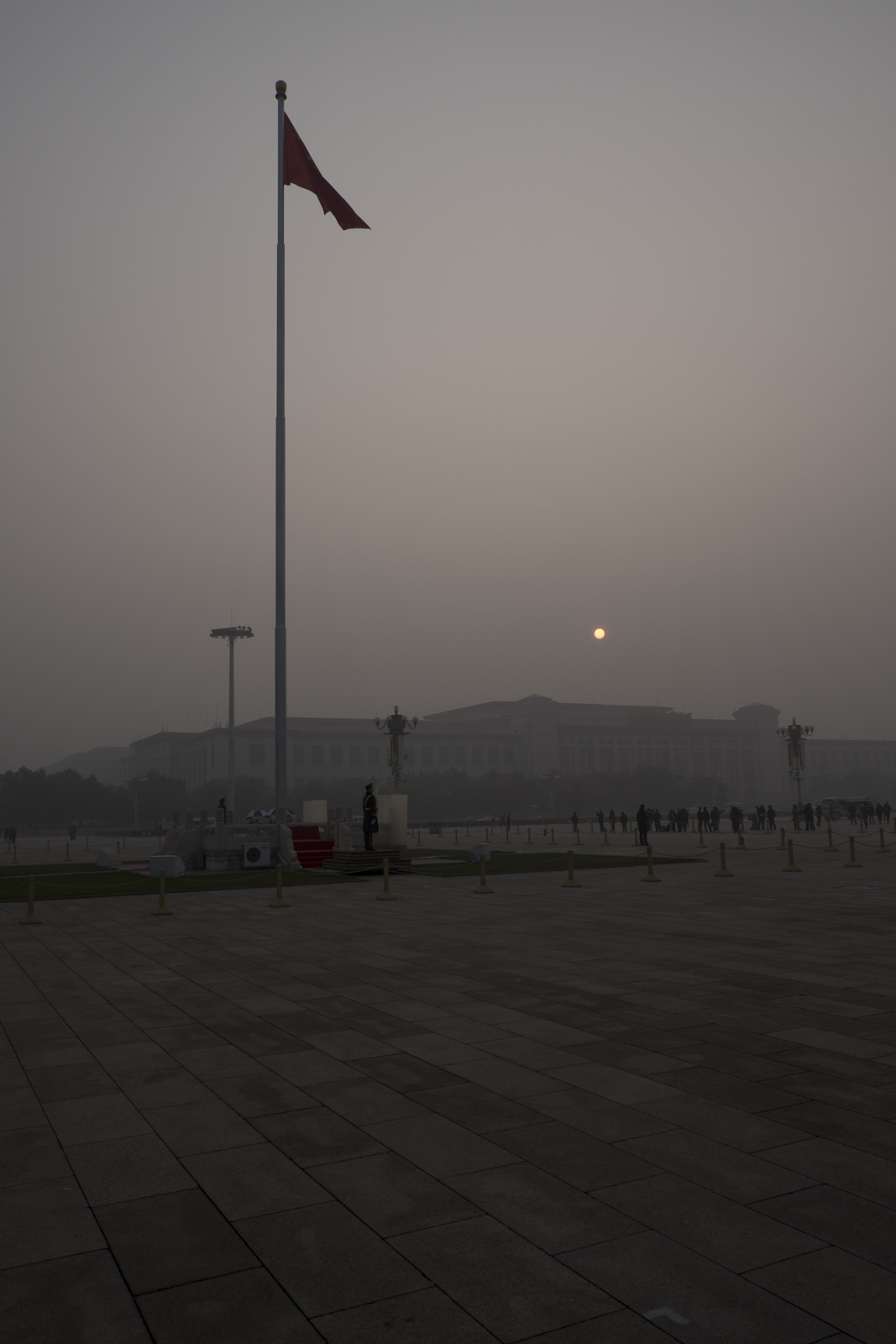 A shy sunrise over Beijing dramatic air pollution in the popular Tiananmen Square.