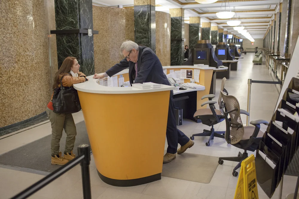 Minutes before the City Clerk's Office closes, Bibi tries to get help to send a written request for her marriage certificate. 