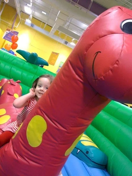 Riding the dino in the toddler area at Monkey Joes