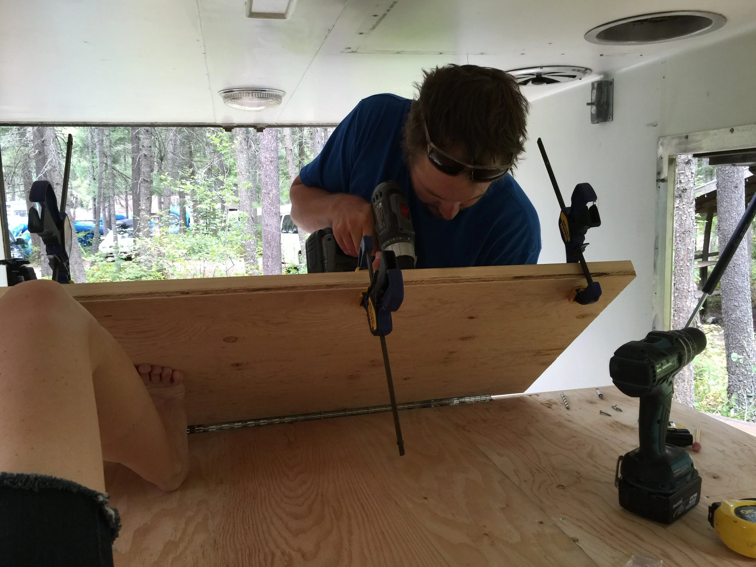 We strengthened the far lip of the fold-out foot of the bed with a 2x6, and then mounted the stow-away support legs to that. I am a large man and I can sit on that 2x6 with no bowing in the wood. 