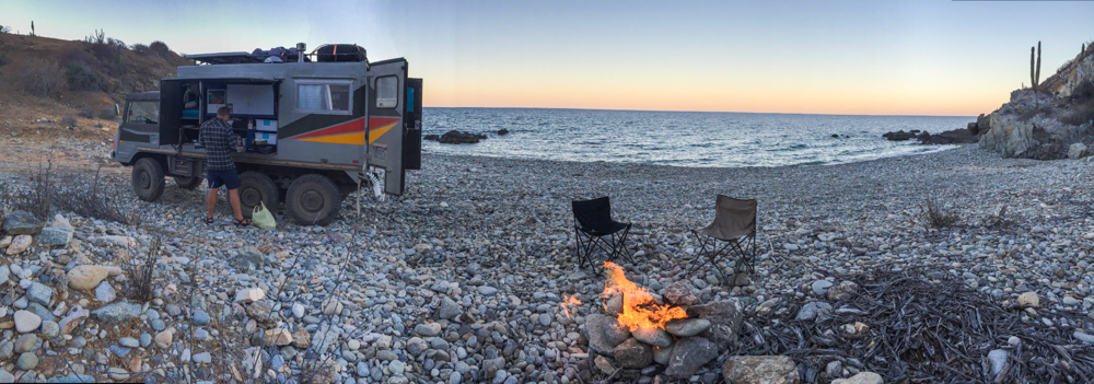 The rocky cove with dinner on the fire.