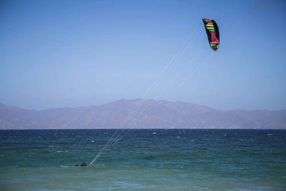 Watching a kite surfer body drag before standing up on his board.