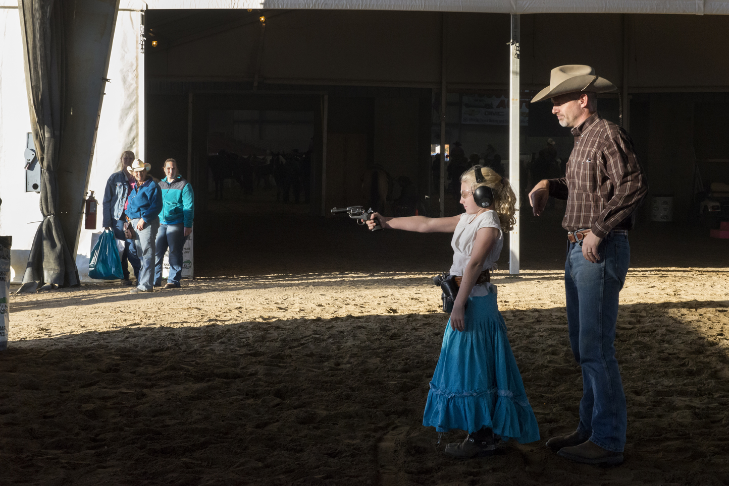 Eric Schreiber teaches Cate Westley, who is in the limited wrangler class, to shoot at a series of ground targets at the Congress shootout.