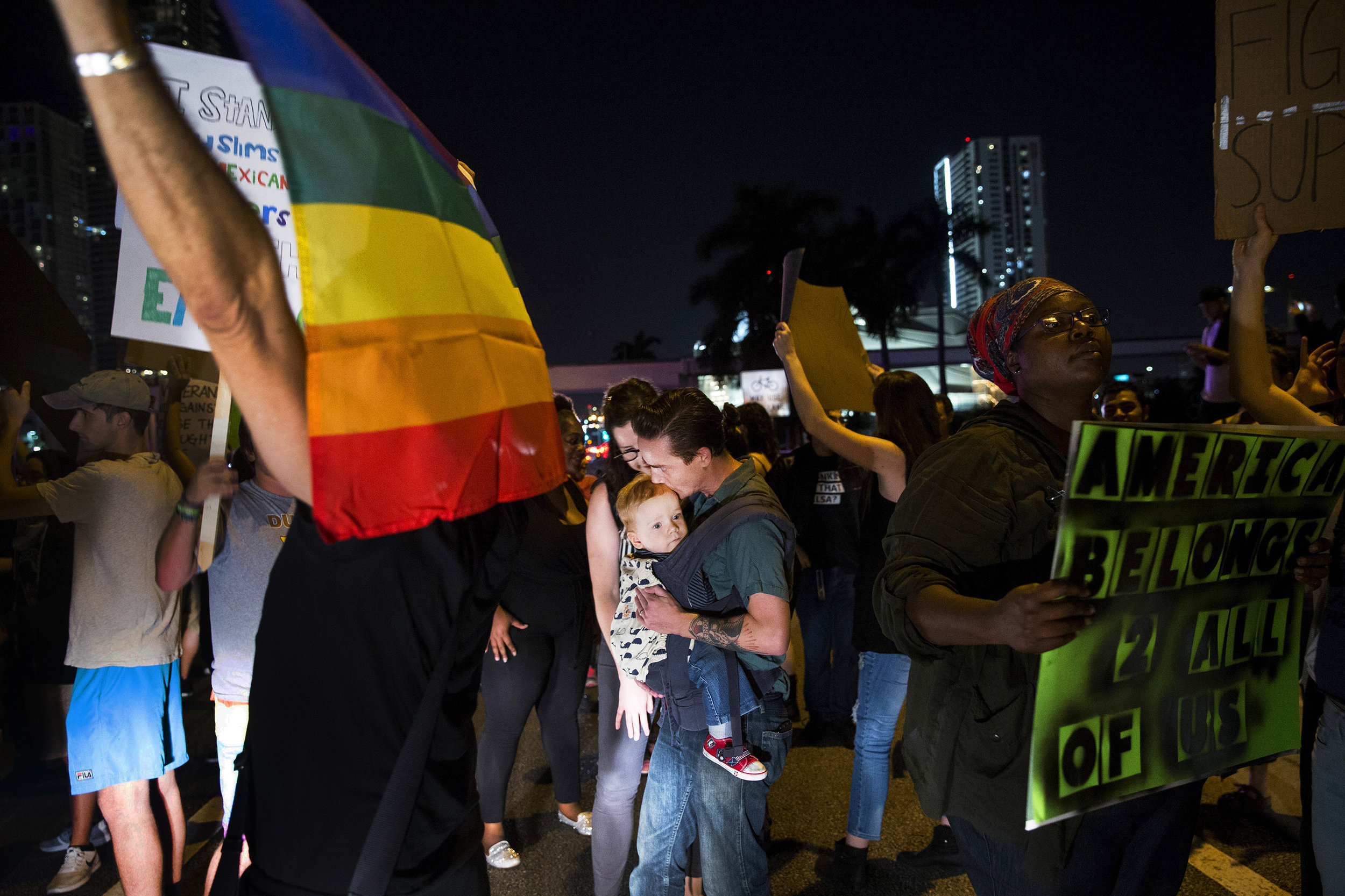 Patrick Griffin, center, kisses his son Patrick Griffin Jr., 18 months, during a non-violent anti-Trump march and protest in downtown Miami, FL on Friday, Nov. 11, 2016. According to one of the group's Facebook pages, the march aimed to warn the people against the dangers of a man like Donald Trump, particularly the encouragement of outspoken hate, racism, anti-islamism, and misogyny. 