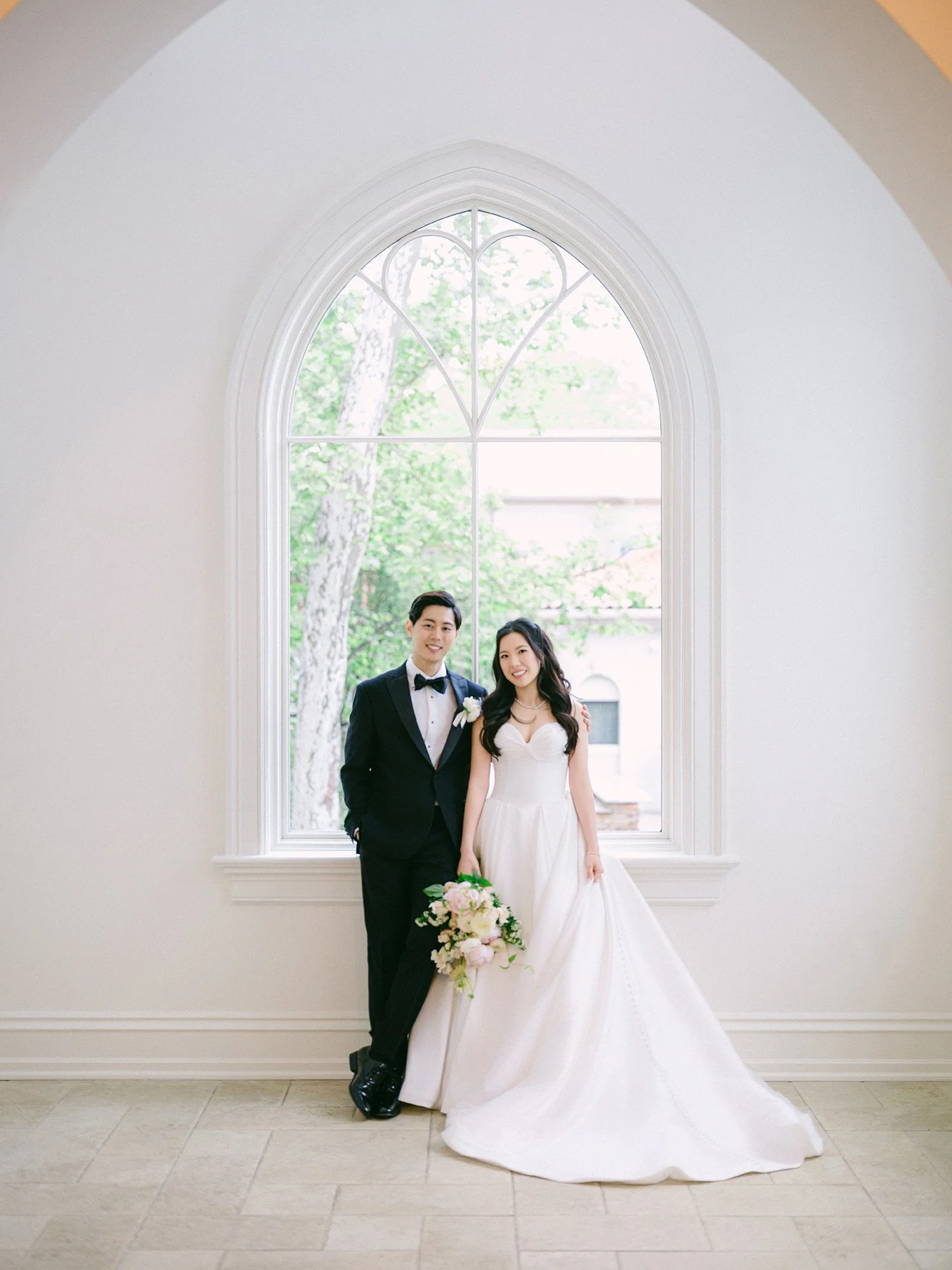  A bright and airy wedding portrait of Joann and Thomas sharing a romantic moment inside the elegant Nanina's in the Park venue. 