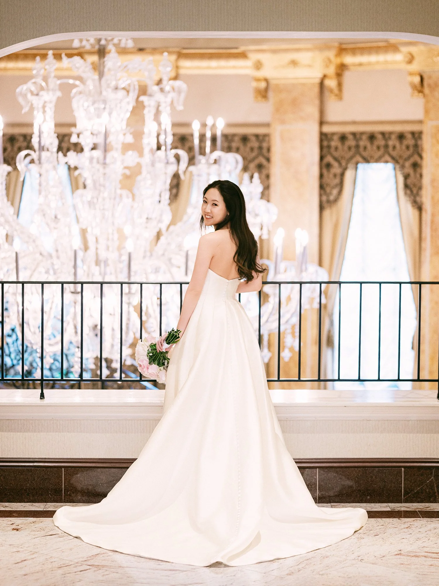  A grand and vibrant wedding portrait of Jenny and Shay sharing a joyful moment inside the luxurious ballroom of The Venetian in New Jersey. 