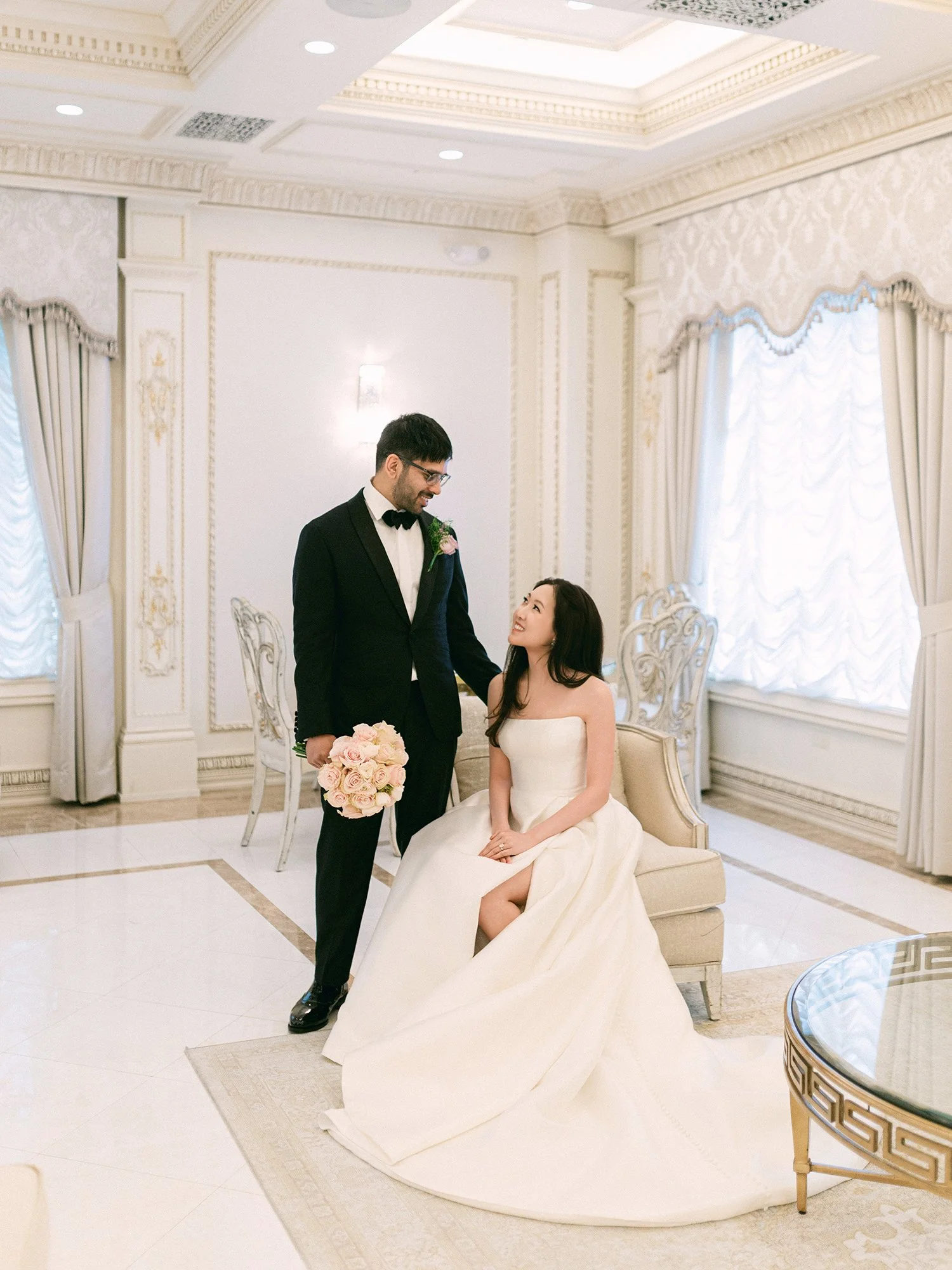  A grand and vibrant wedding portrait of Jenny and Shay sharing a joyful moment inside the luxurious ballroom of The Venetian in New Jersey. 