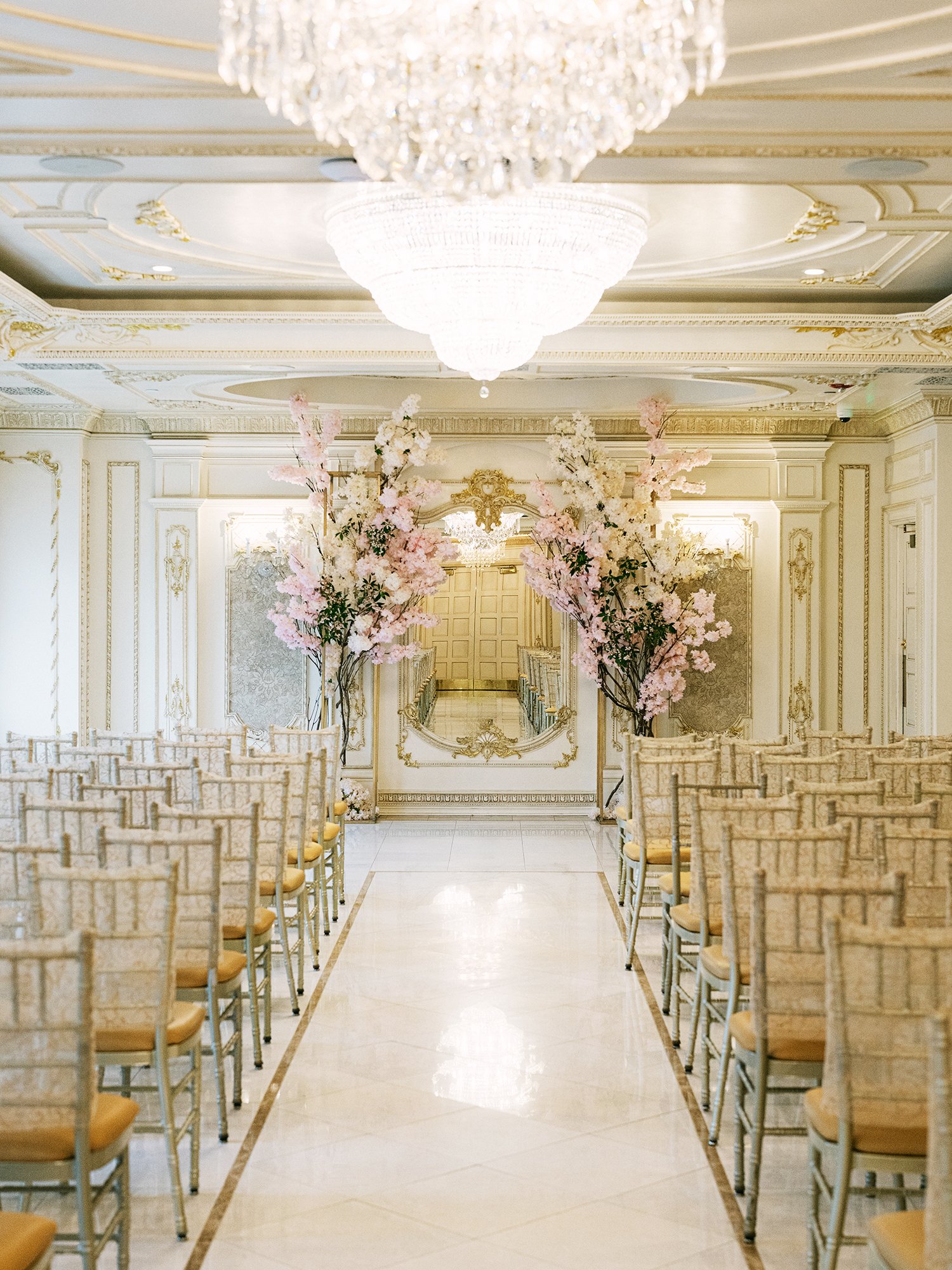  A grand and vibrant wedding portrait of Jenny and Shay sharing a joyful moment inside the luxurious ballroom of The Venetian in New Jersey. 