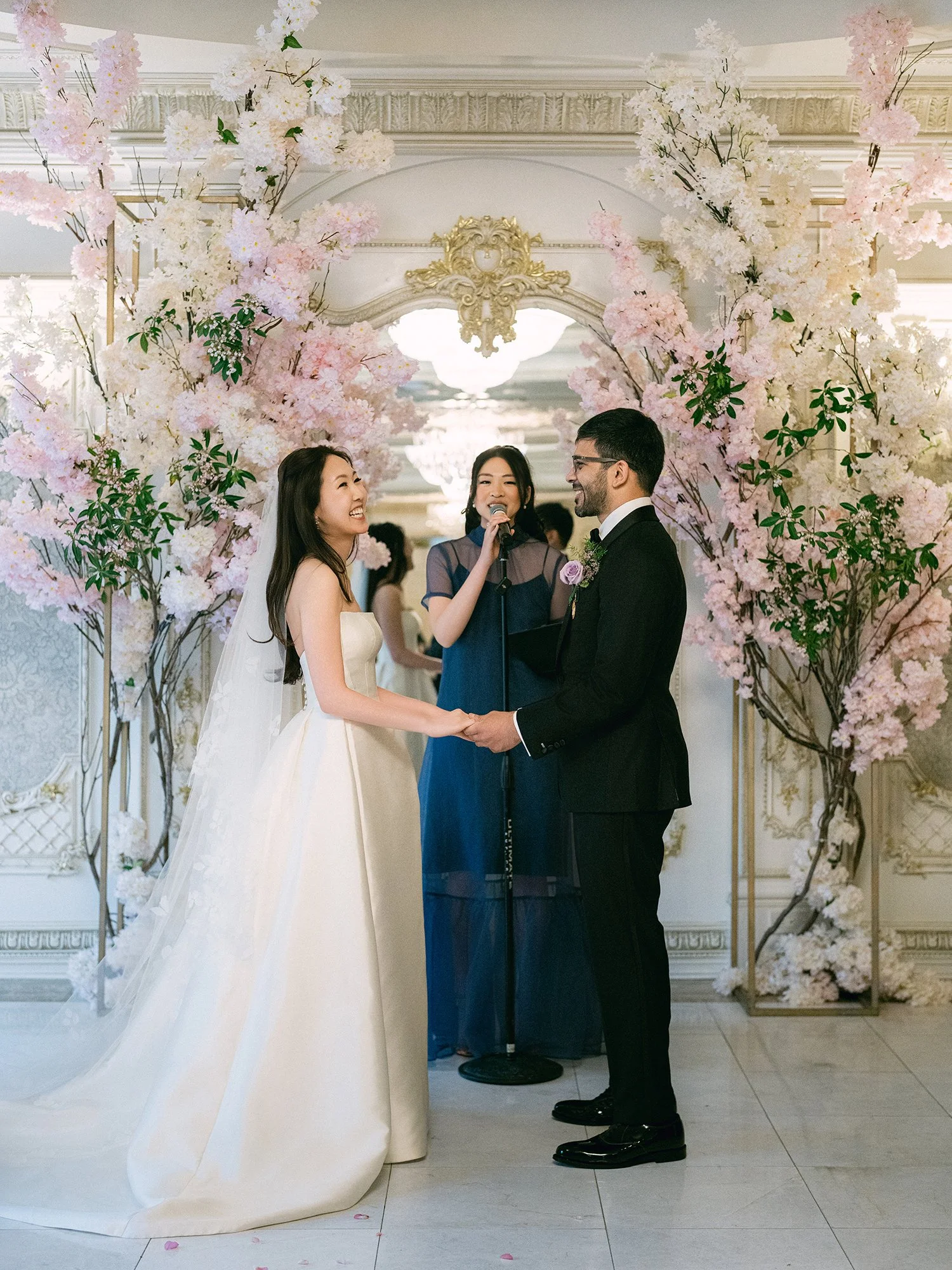  A grand and vibrant wedding portrait of Jenny and Shay sharing a joyful moment inside the luxurious ballroom of The Venetian in New Jersey. 