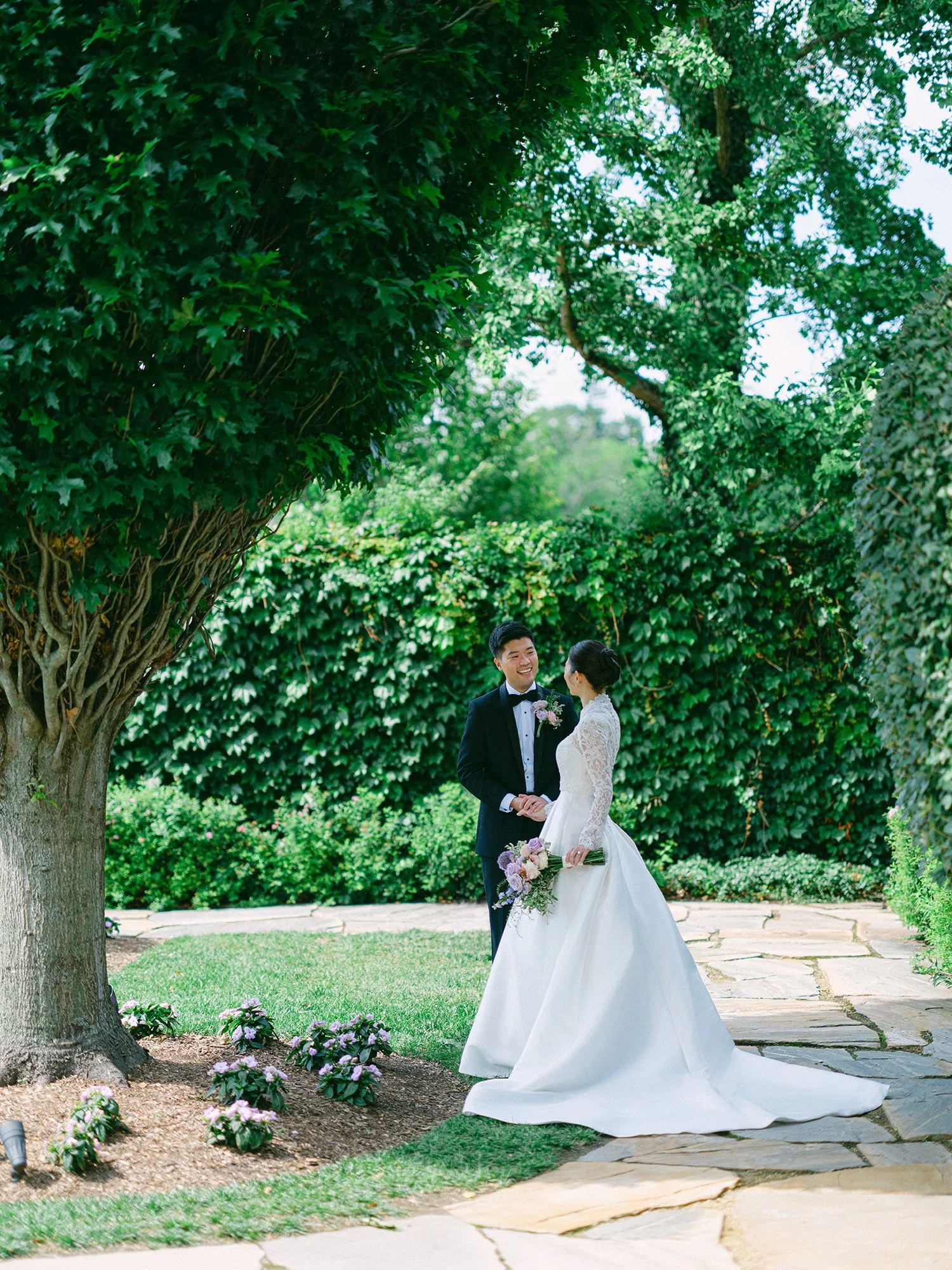 Wedding portrait of Amanda and Michael smiling in front of the historic mansion at Hamilton Farm Golf Club by Haseok Chung Studio.