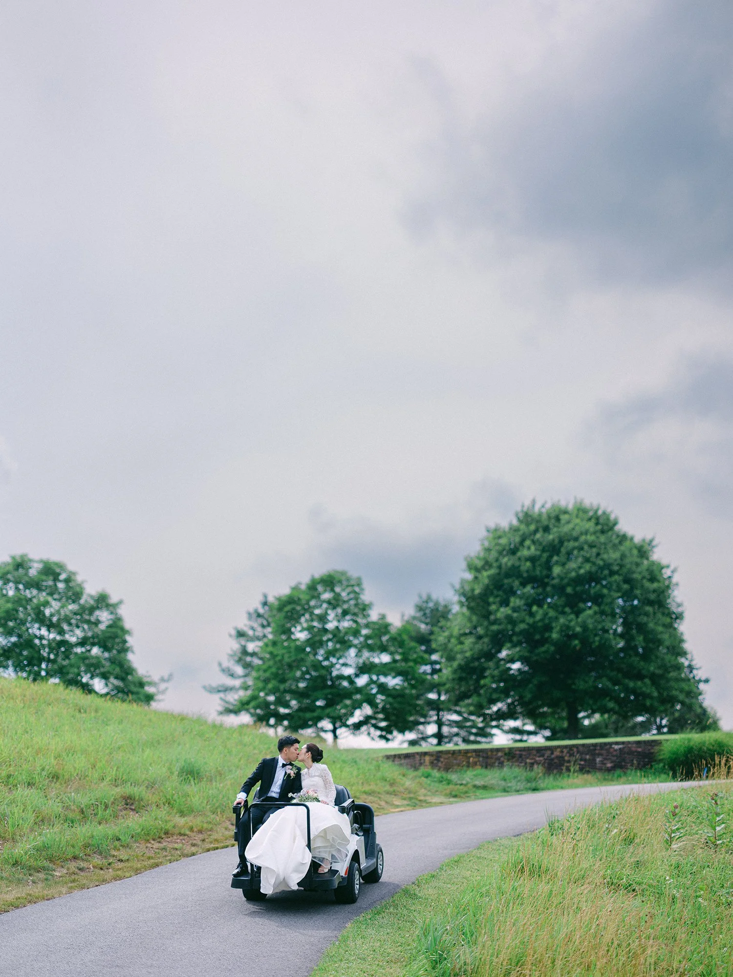 Wedding portrait of Amanda and Michael smiling in front of the historic mansion at Hamilton Farm Golf Club by Haseok Chung Studio.