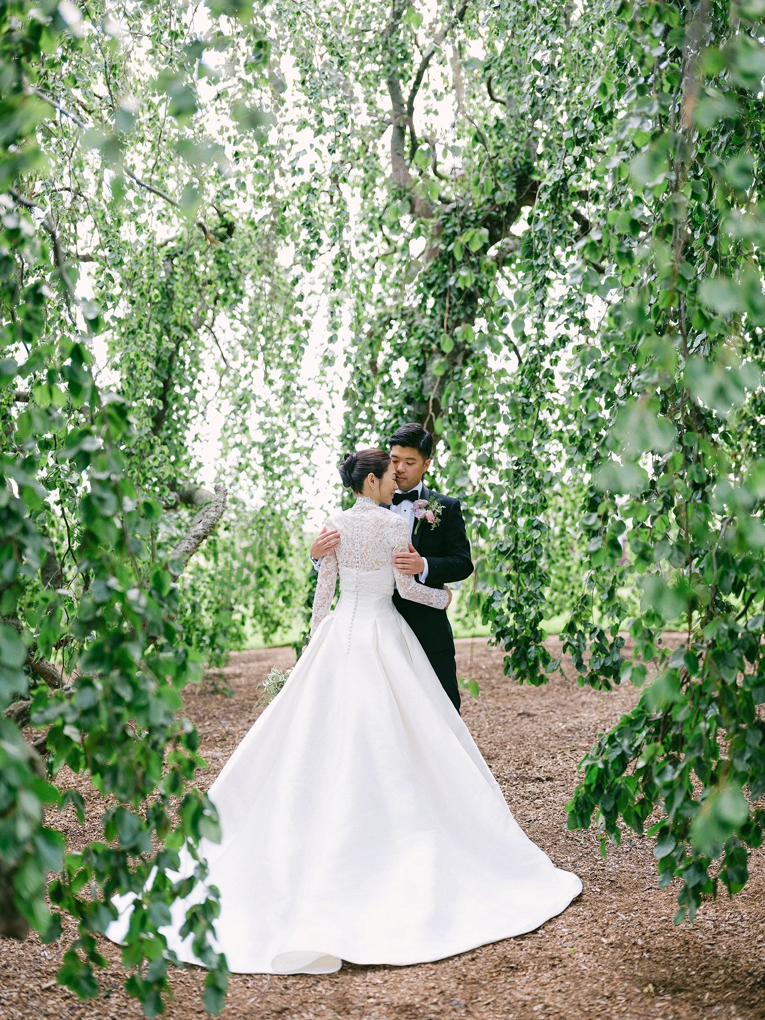 Wedding portrait of Amanda and Michael smiling in front of the historic mansion at Hamilton Farm Golf Club by Haseok Chung Studio.