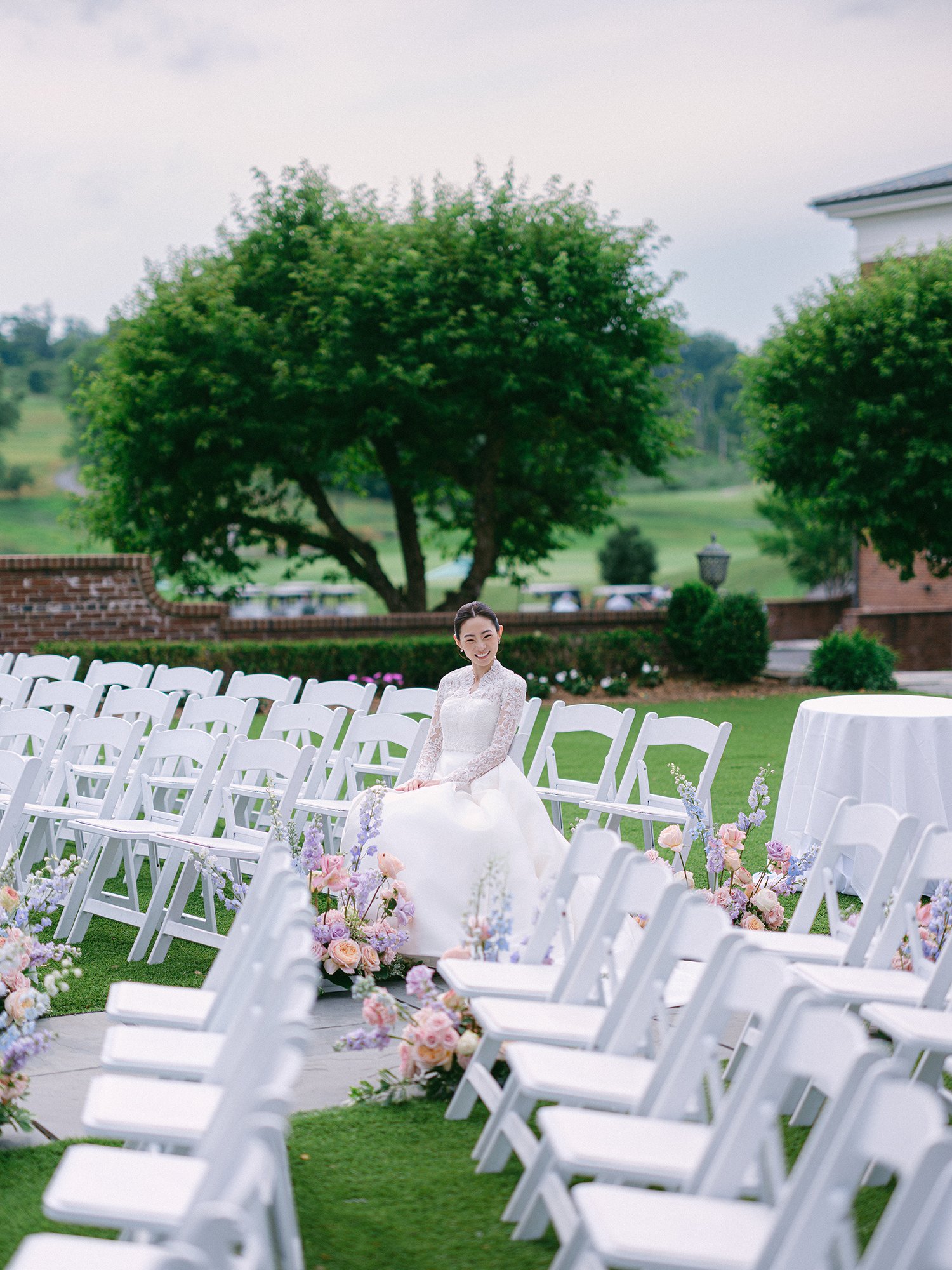 Wedding portrait of Amanda and Michael smiling in front of the historic mansion at Hamilton Farm Golf Club by Haseok Chung Studio.