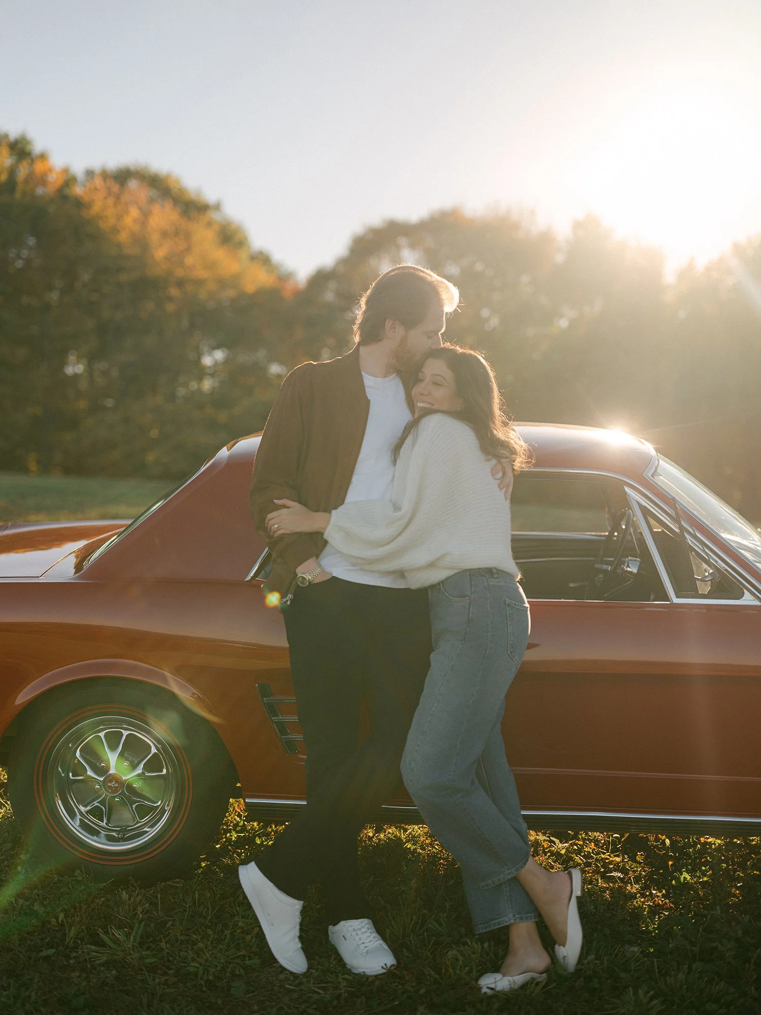 The couple with a red 1960s Ford Mustang at their engagement session in Milton, New York