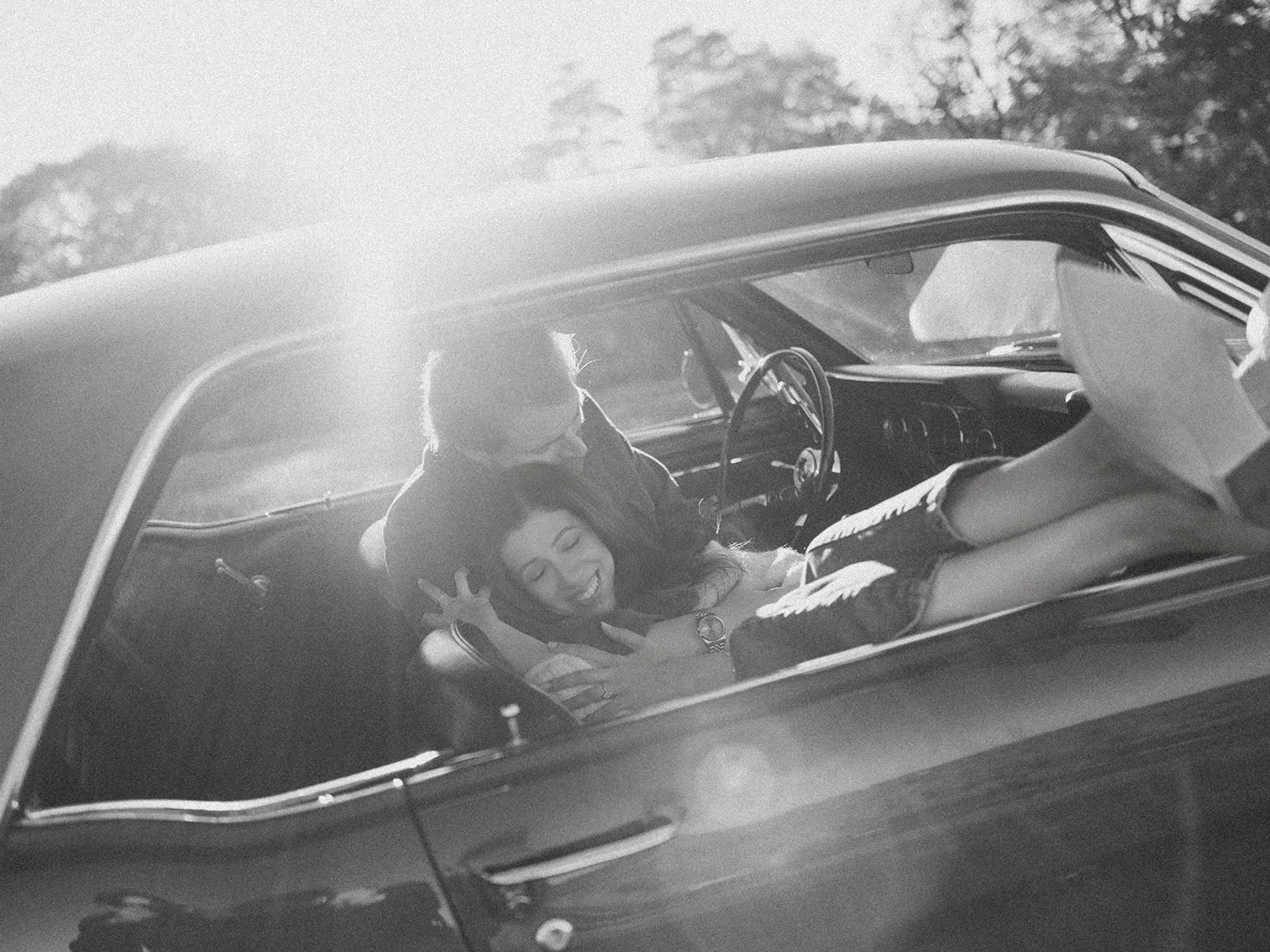 The couple with a red 1960s Ford Mustang at their engagement session in Milton, New York