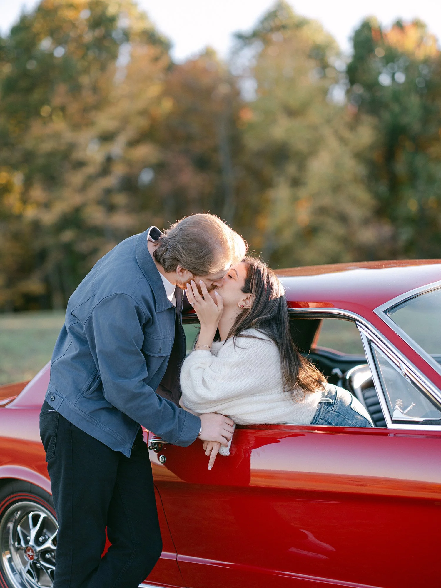 The couple with a red 1960s Ford Mustang at their engagement session in Milton, New York