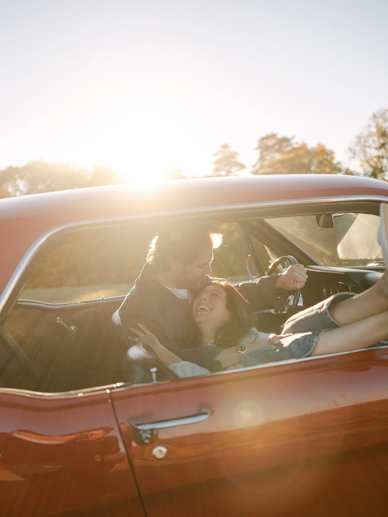 The couple with a red 1960s Ford Mustang at their engagement session in Milton, New York