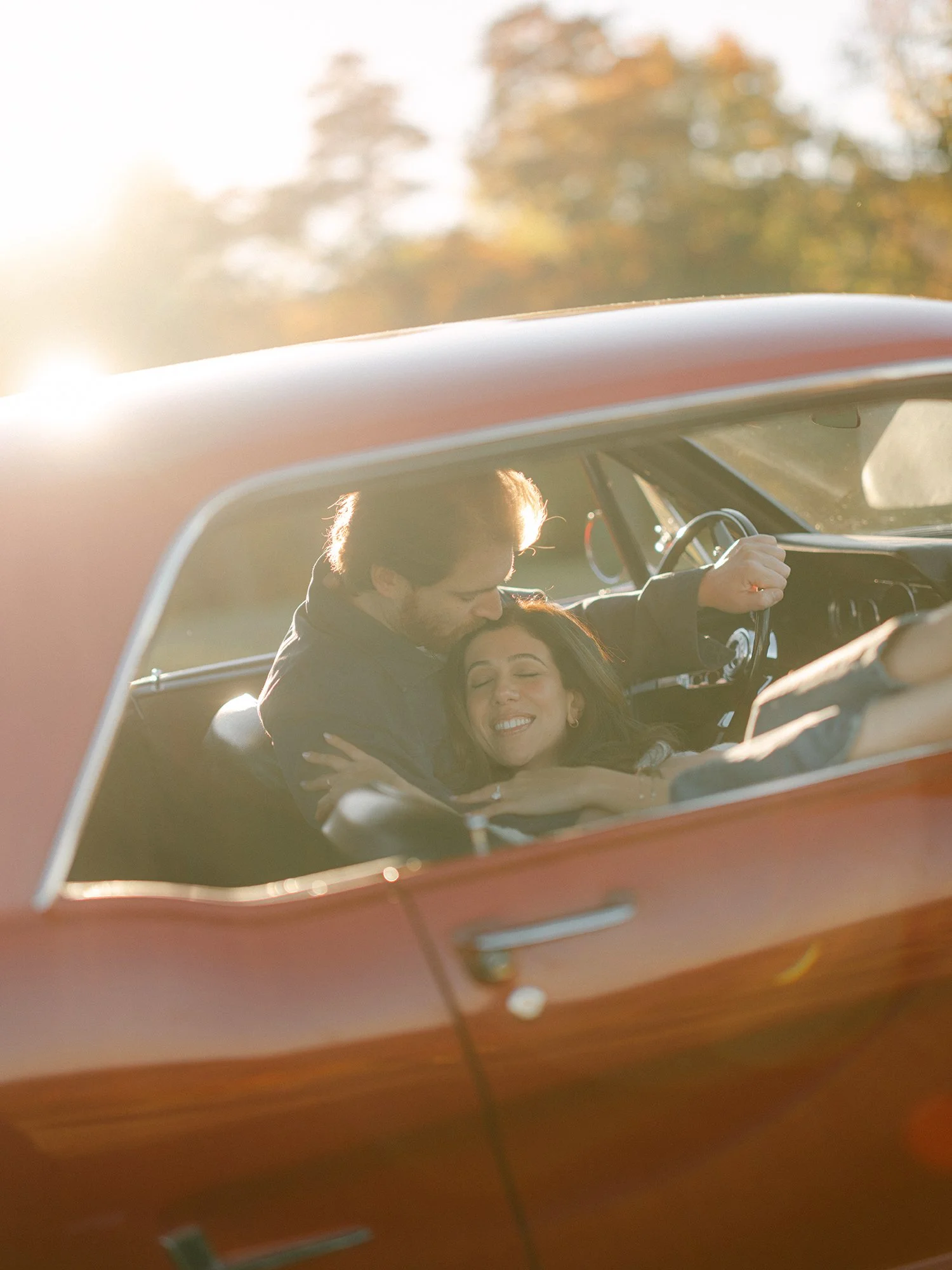 The couple with a red 1960s Ford Mustang at their engagement session in Milton, New York