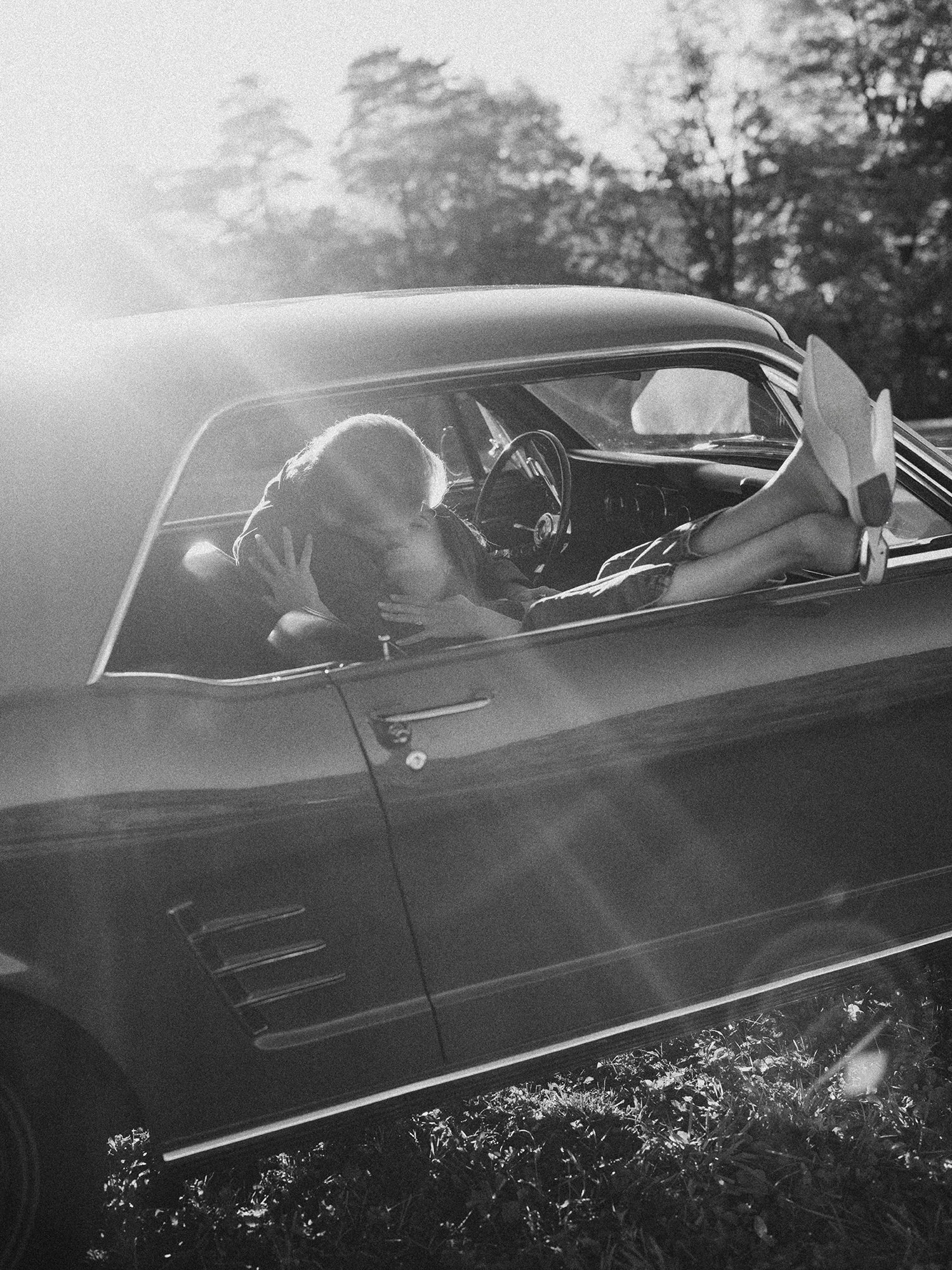 The couple with a red 1960s Ford Mustang at their engagement session in Milton, New YorkThe couple with a red 1960s Ford Mustang at their engagement session in Milton, New York