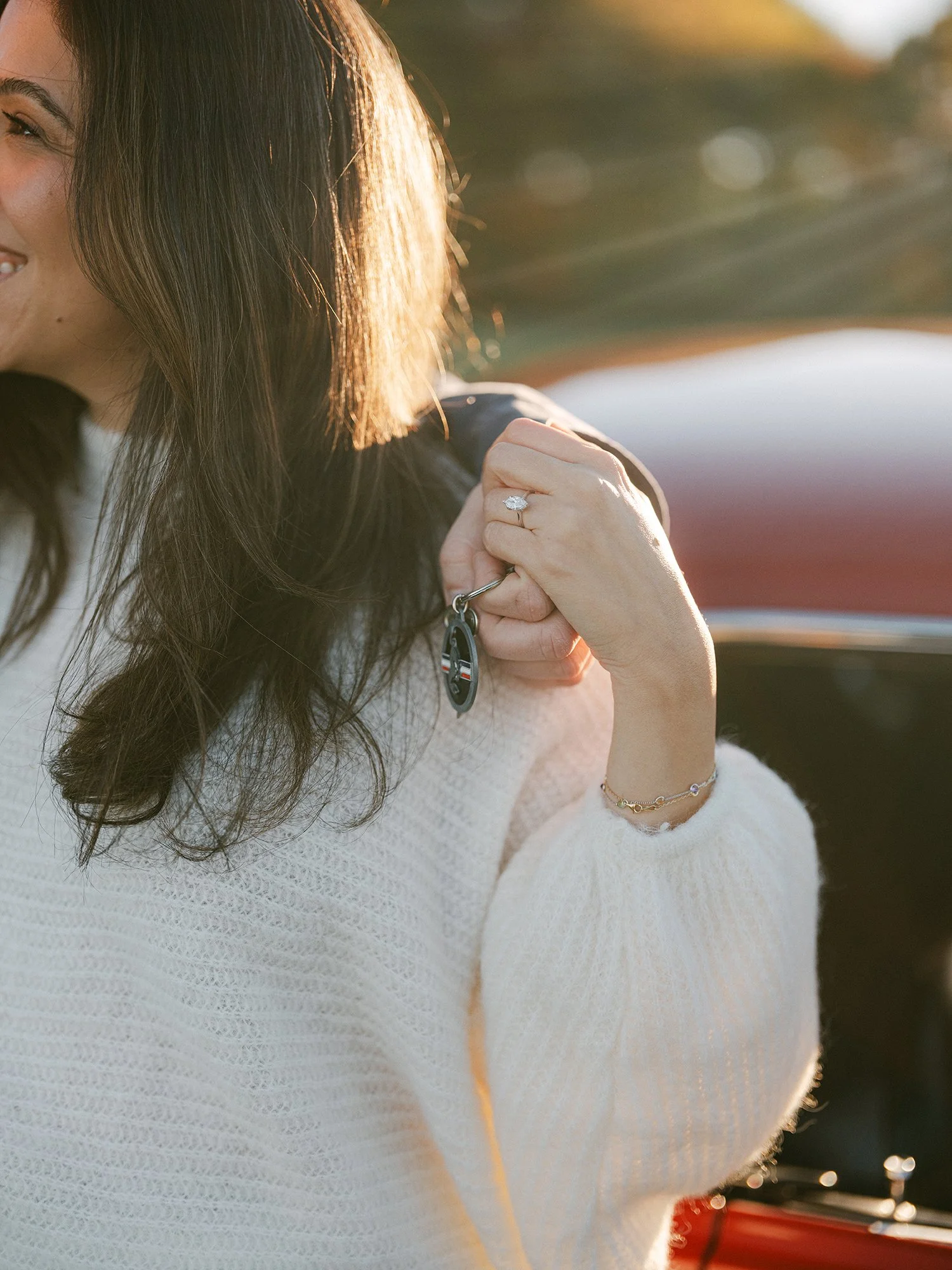 Close-up of Sandra's engagement ring, Daniel holding her hand at golden hour