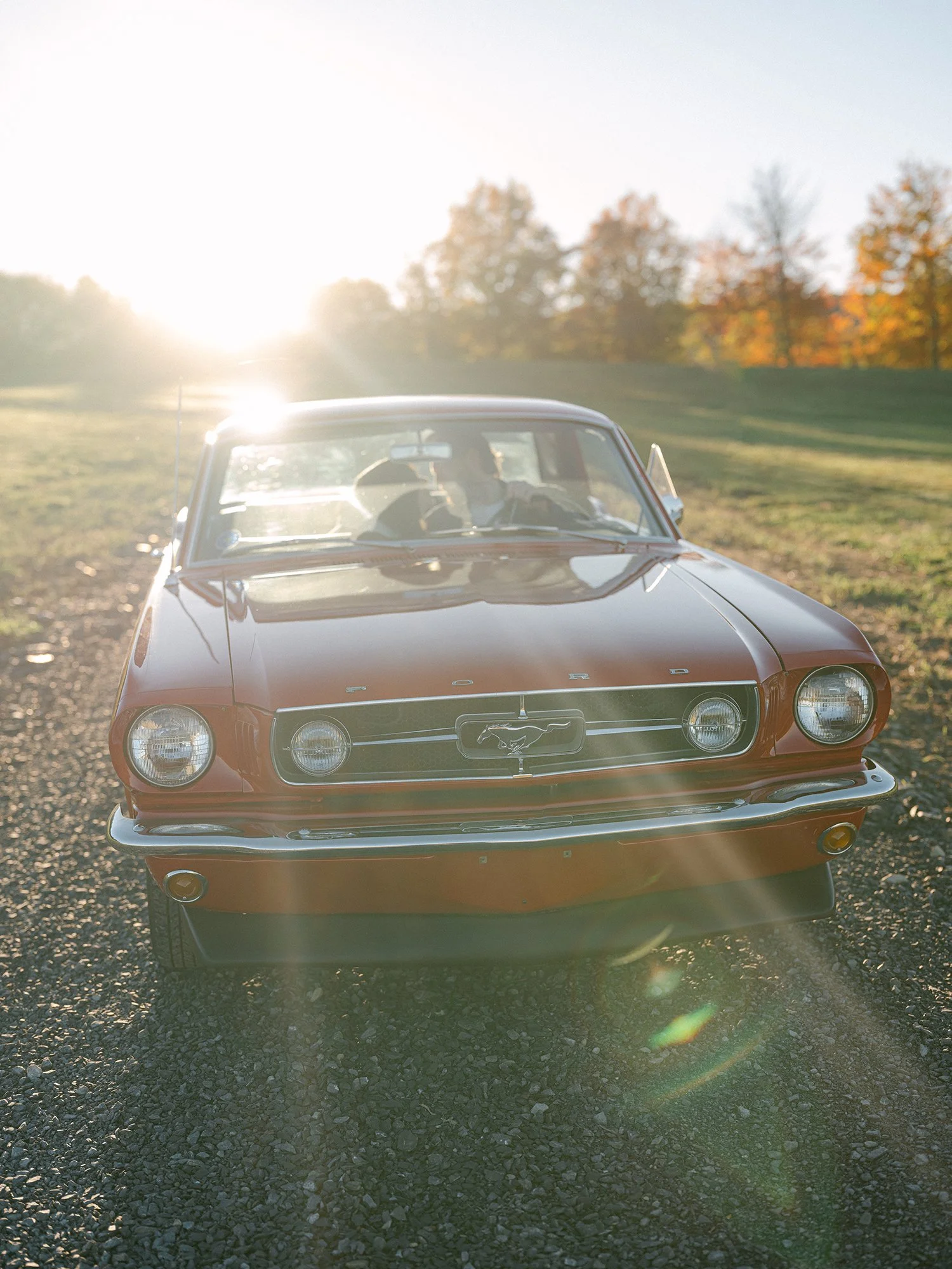 The couple with a red 1960s Ford Mustang at their engagement session in Milton, New York