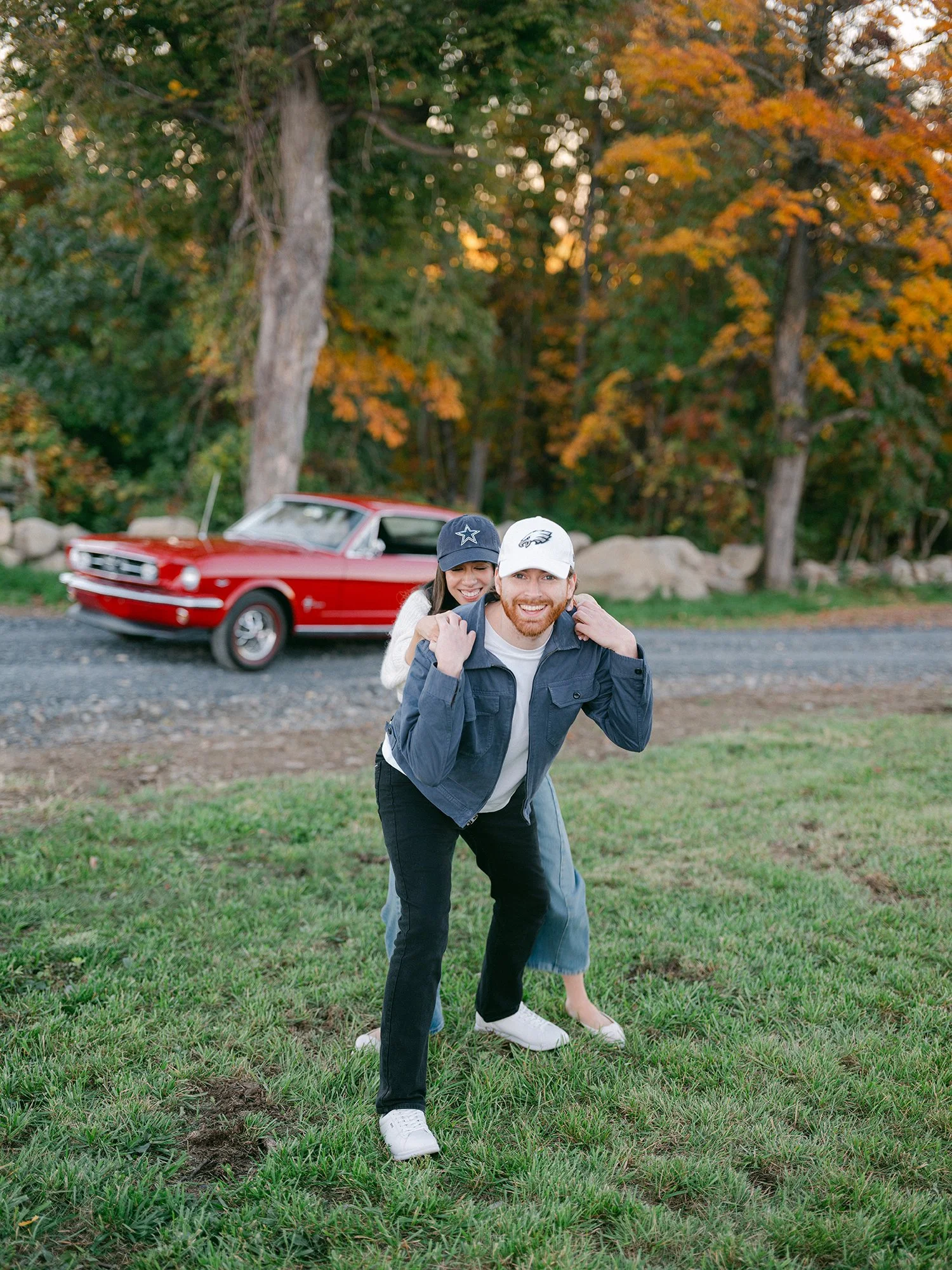 The couple with a red 1960s Ford Mustang at their engagement session in Milton, New York