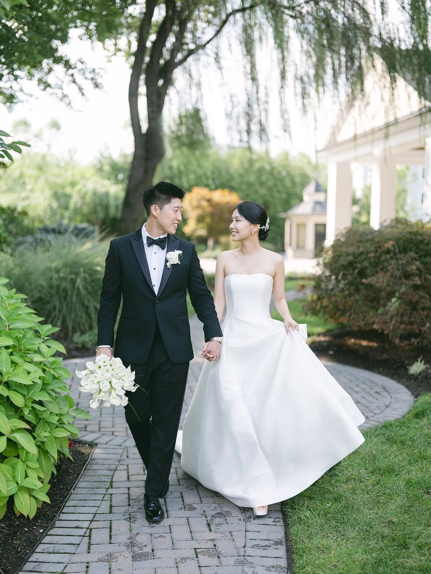 Bride and groom walking through the gardens at The Rockleigh in New Jersey