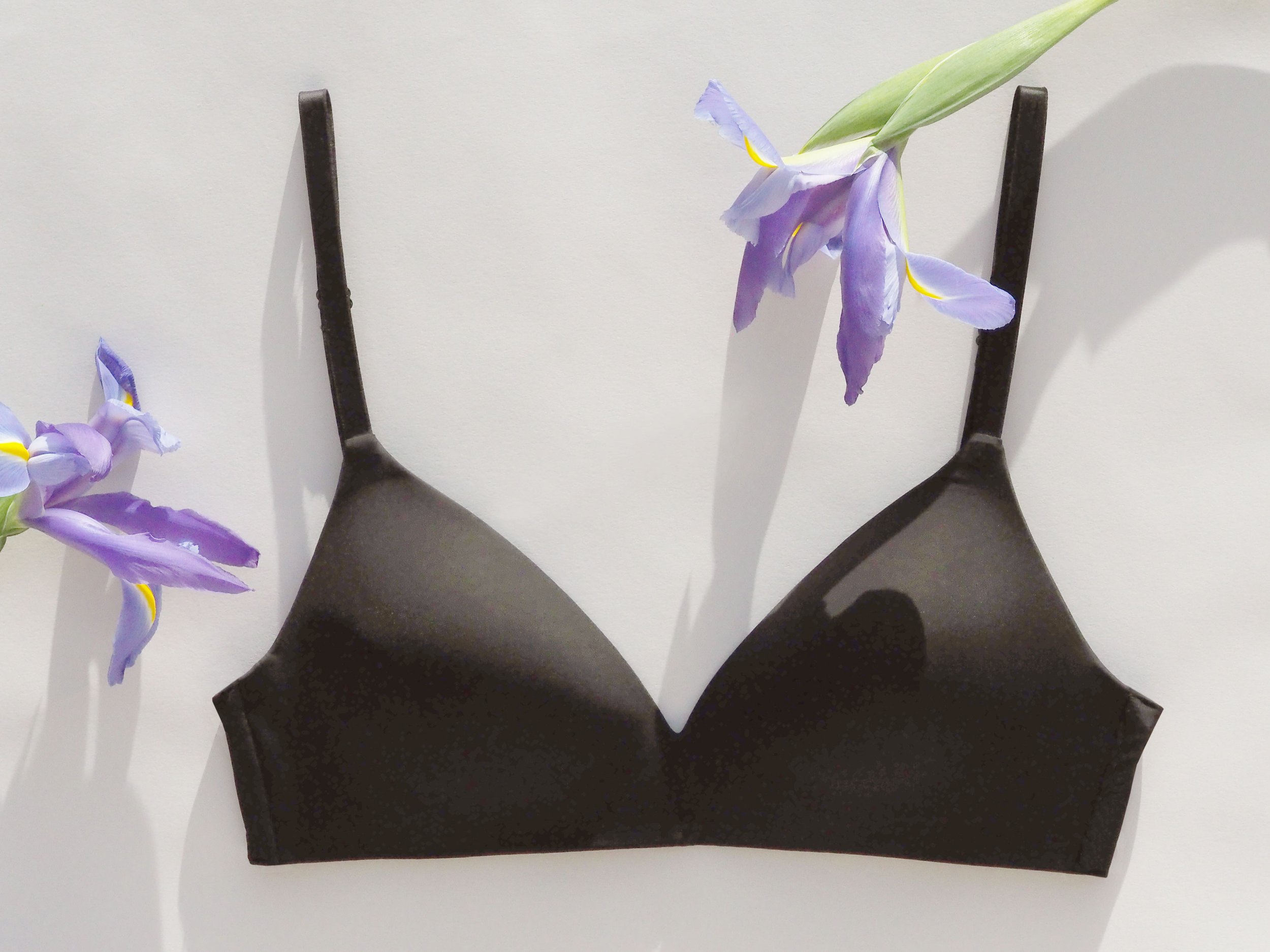 Black bra with purple iris flowers on a light background