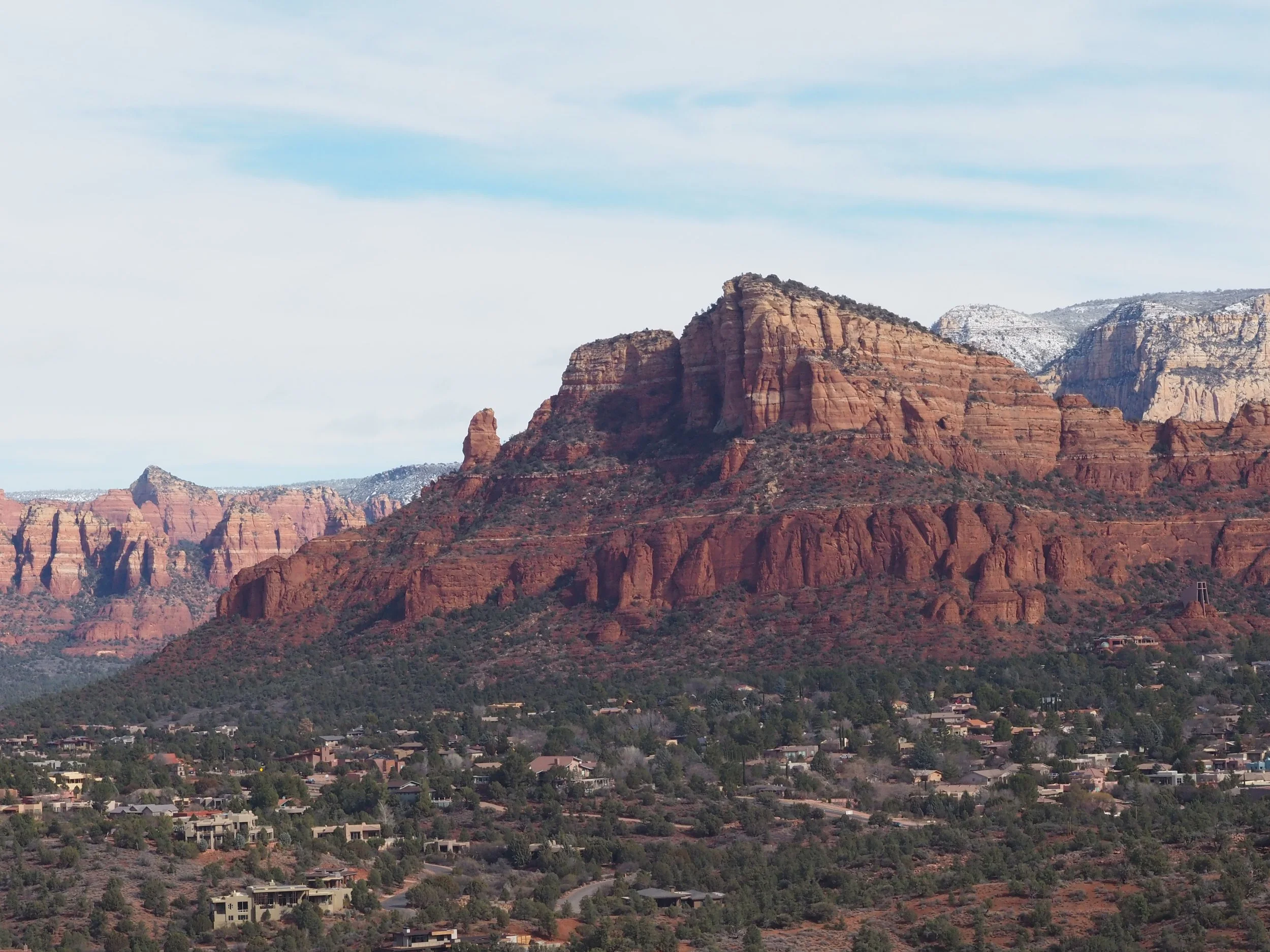 Red rock formations in Sedona, Arizona with green vegetation and scattered houses