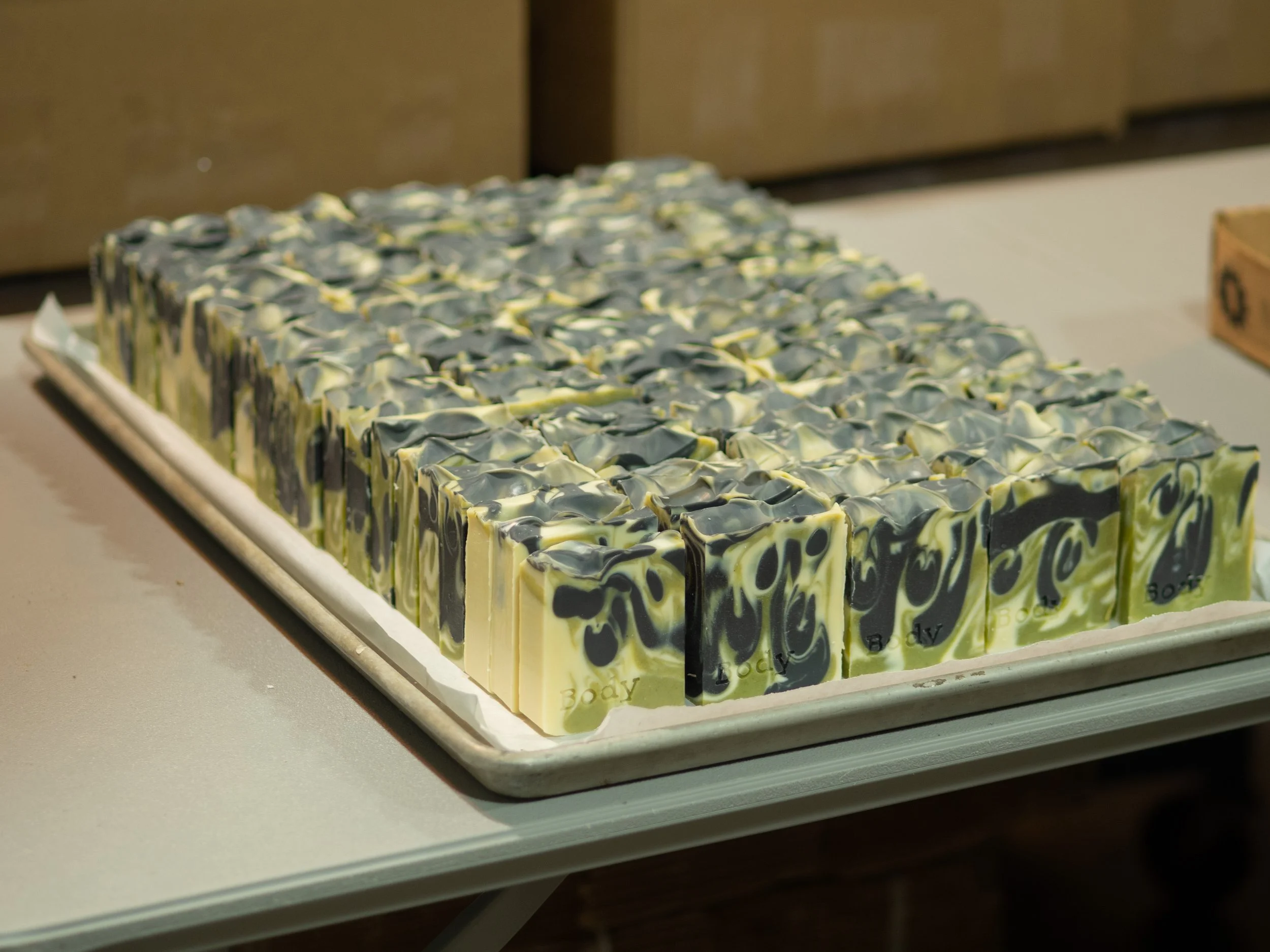 Tray of artisanal soap bars with black and cream swirl pattern