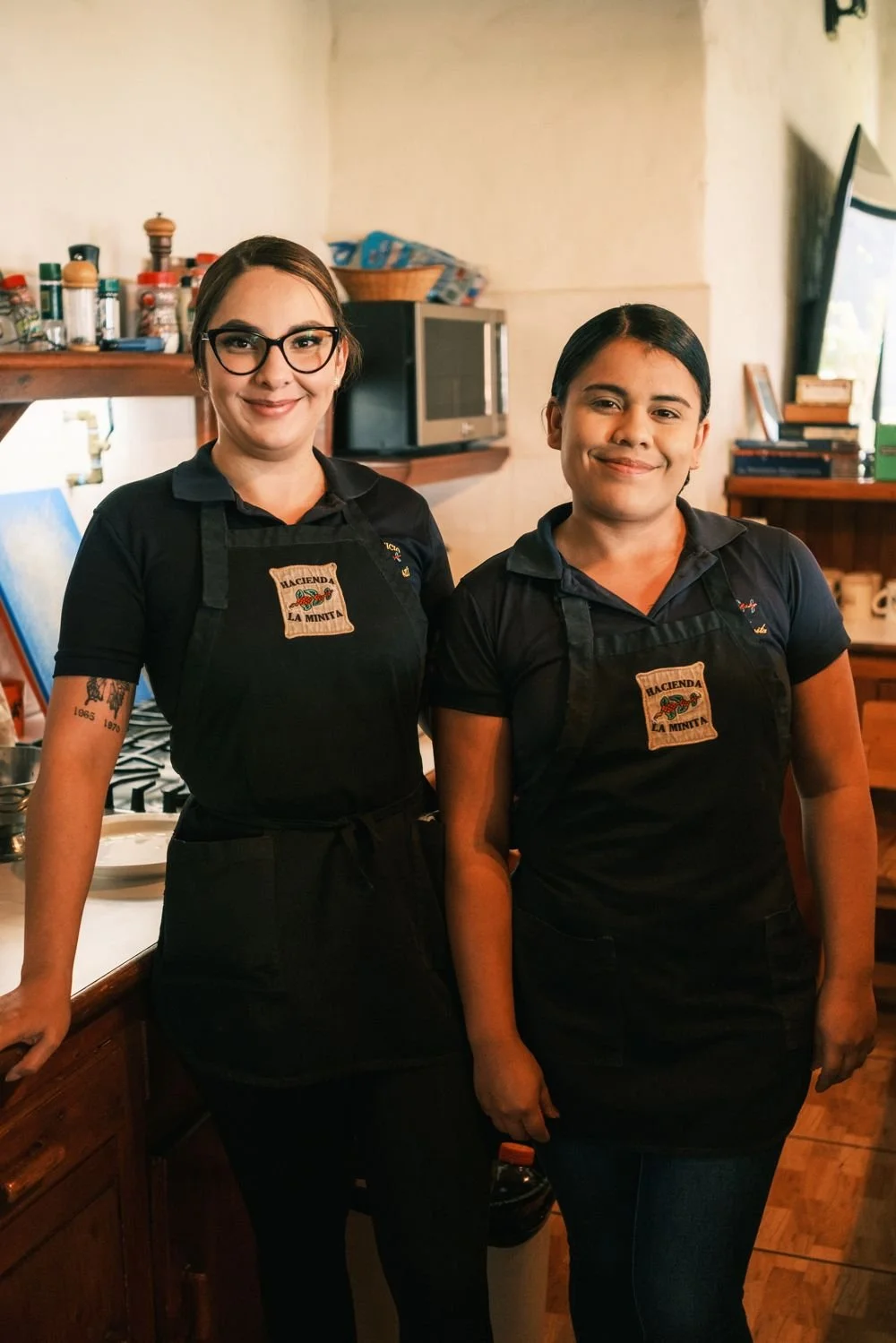 Two members of the La Minita kitchen team in farm aprons