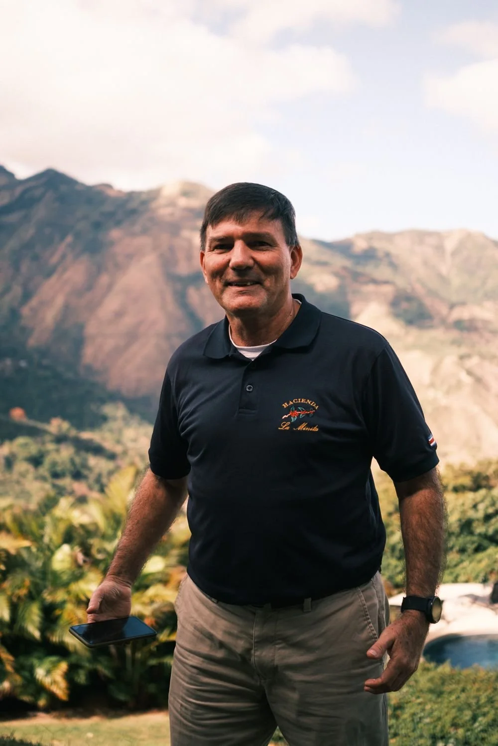A La Minita host smiling with the valley and mountains behind him