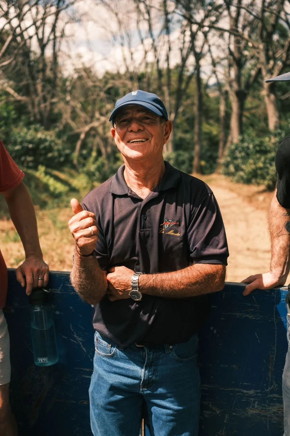 A smiling La Minita farmer giving a thumbs up from the back of the farm truck