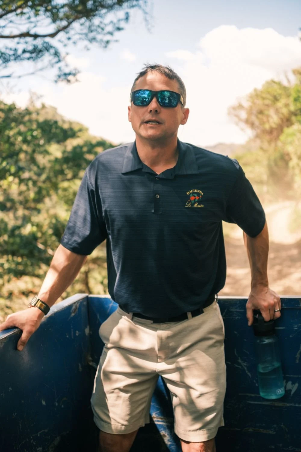 A farm guide in sunglasses leading the tour from the back of the truck