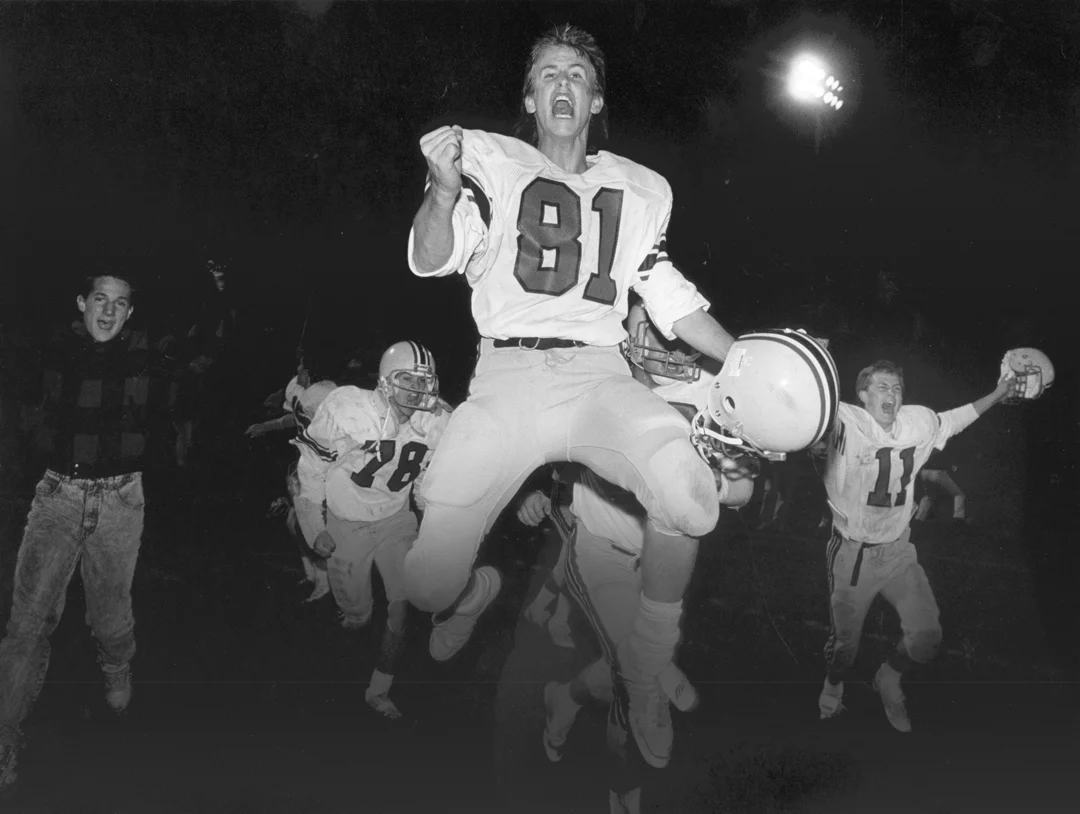 Members of the Garrigan High School football team celebrate after winning a playoff game against a county rival. This image won Best Of Show in the 1987 Iowa Press Photographers Association while I was working for the Kossuth County Advance in Algon…