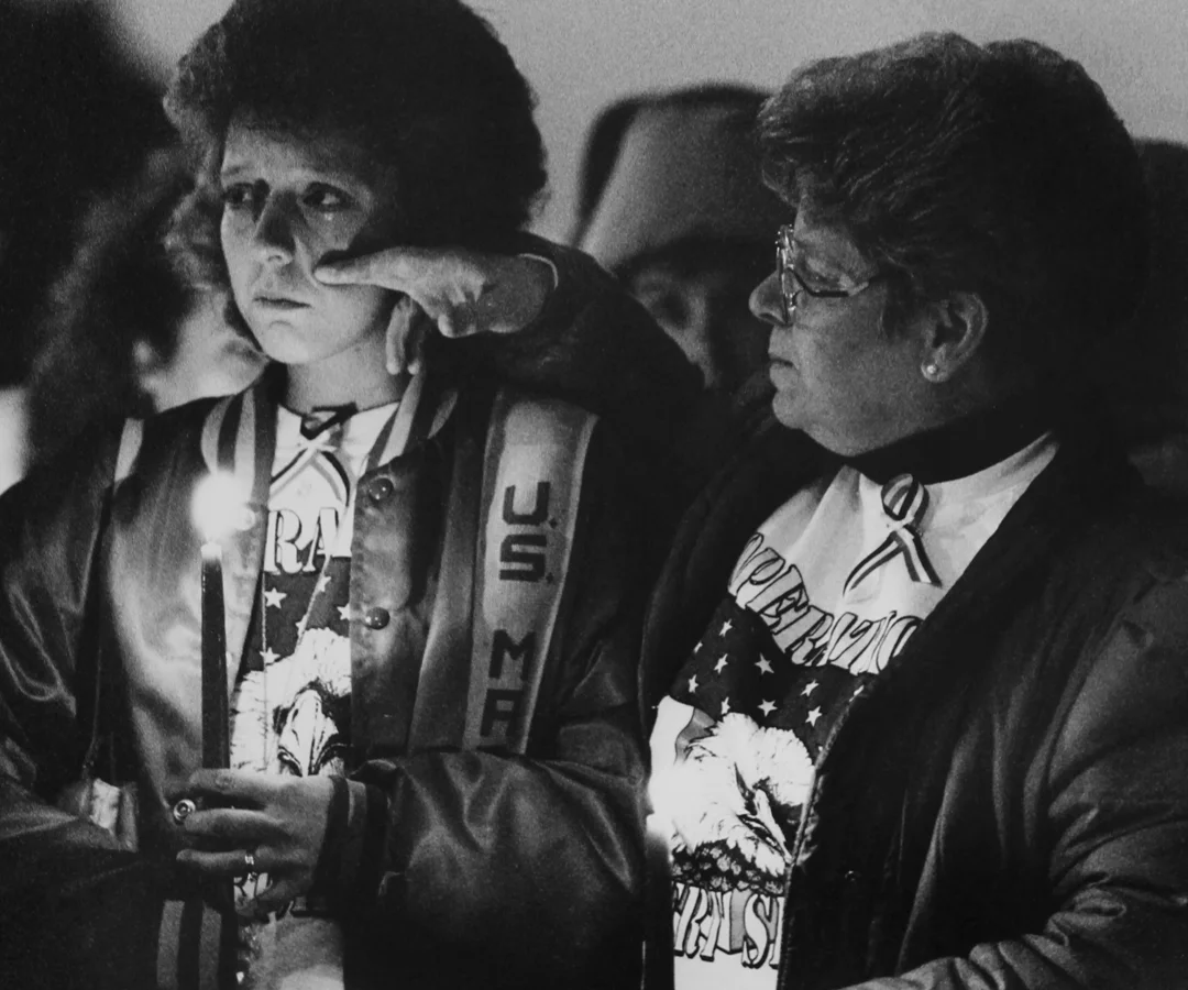 A woman wipes a tear from her daughter's cheek during a candlelight vigil for Jasper, Ind., troops. The daughter's husband was a Marine stationed in Iraq.