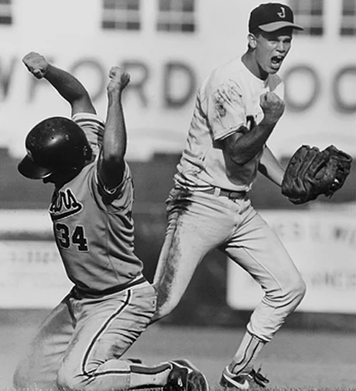 An Jasper High School player celebrates after making an out at second base in a tournament game.