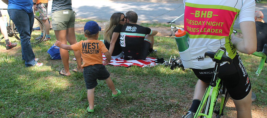 A mix of spectators and racers are drawn to the start / finish line.